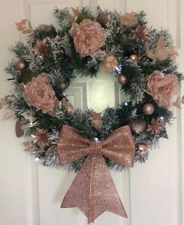 Christmas round wreath with peachy pink peonies with large rose gold bow and battery operated fairy lights