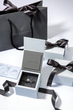 Load image into Gallery viewer,  Lab Grown Diamonds in 9 carat white gold and set with a brilliant lab grown diamond centre stone framed by a halo of pavé set diamonds shown in white gift box with grey gift bag.
