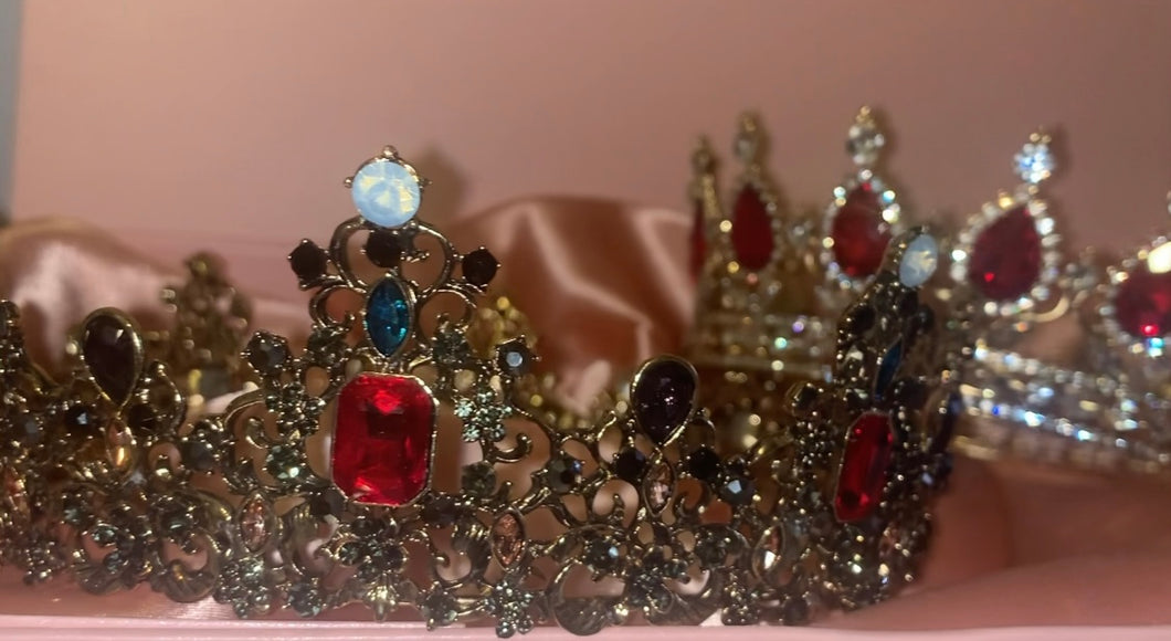 Couples Crowns for a King and Queen with faux rubies, diamonds, opals and saphires set in gold coloured crowns.