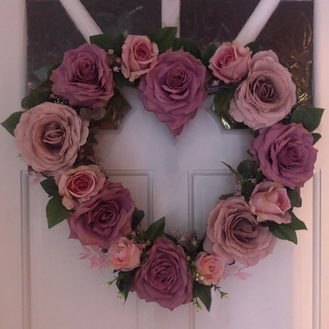 Heart shaped door wreath with real look mauve and antique rose faux roses with baby pink gyp and green foliage. 